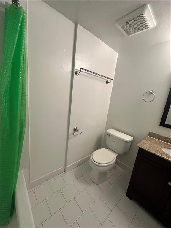 bathroom with toilet, vanity, tile patterned flooring, and shower / tub combo with curtain