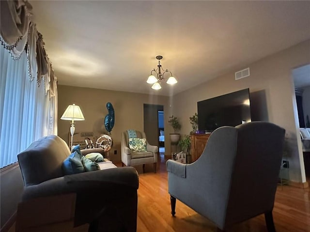 living room with light wood-style flooring and a chandelier