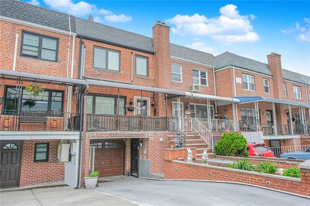 30-30 78th St, Queens, NY 11370 - view of front facade featuring brick siding, a garage, driveway, and a chimney