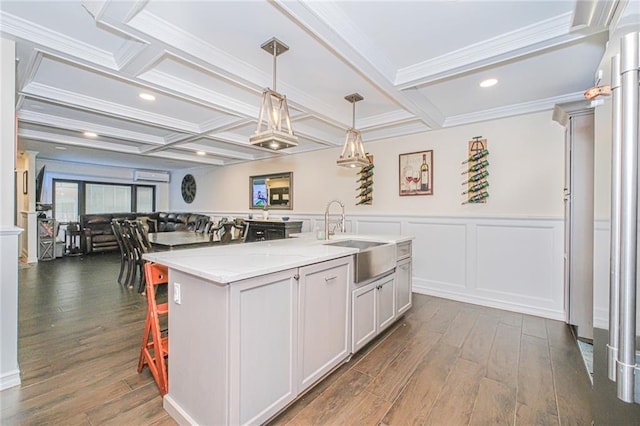 30-30 78th St, Queens, NY 11370 - kitchen featuring a sink, dark wood-type flooring, coffered ceiling, light stone counters, and decorative light fixtures