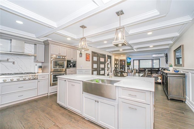 30-30 78th St, Queens, NY 11370 - kitchen featuring appliances with stainless steel finishes, a sink, coffered ceiling, dark wood finished floors, and open floor plan