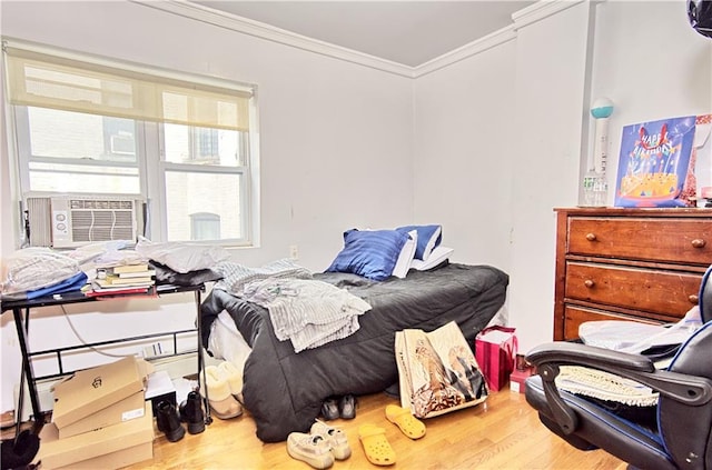bedroom with crown molding, cooling unit, and wood finished floors