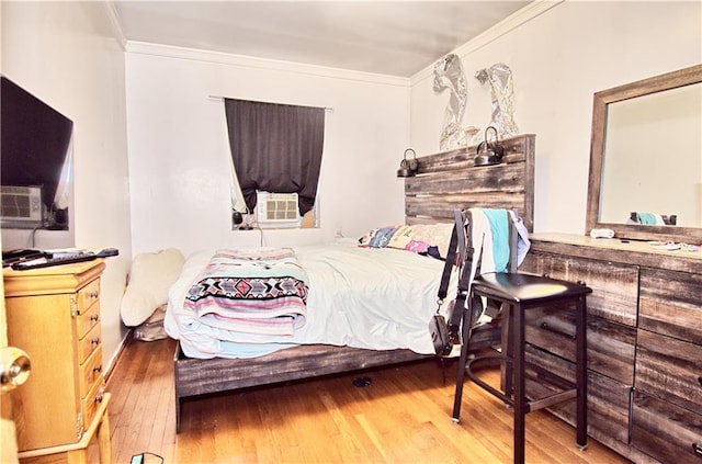 bedroom featuring crown molding, hardwood / wood-style flooring, and cooling unit