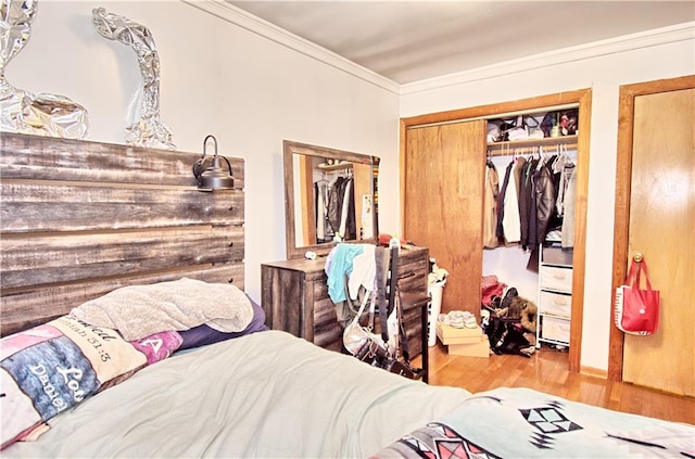 bedroom with wood finished floors and crown molding