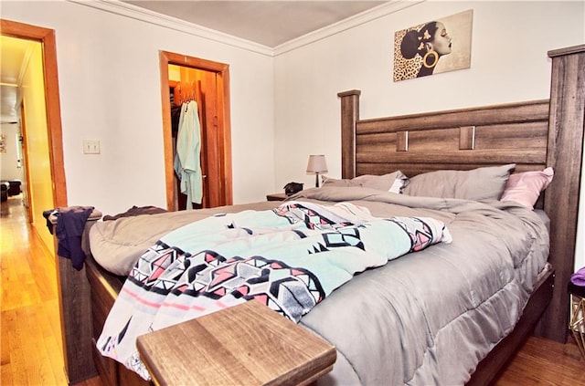 bedroom with crown molding and wood finished floors