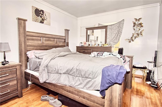 bedroom featuring light wood finished floors and crown molding