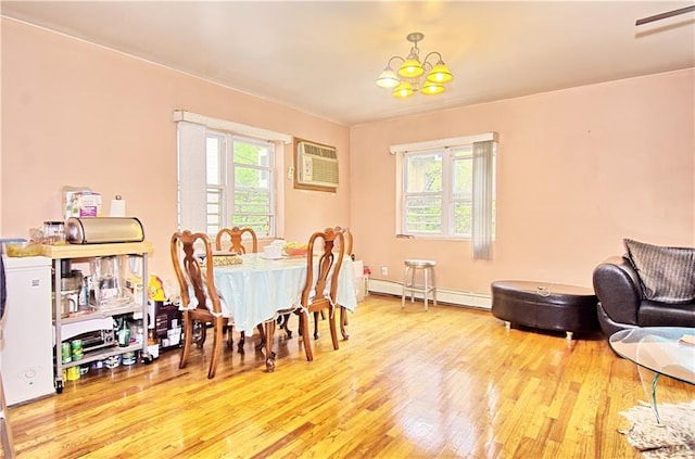 dining room featuring baseboard heating, wood finished floors, an AC wall unit, and a chandelier