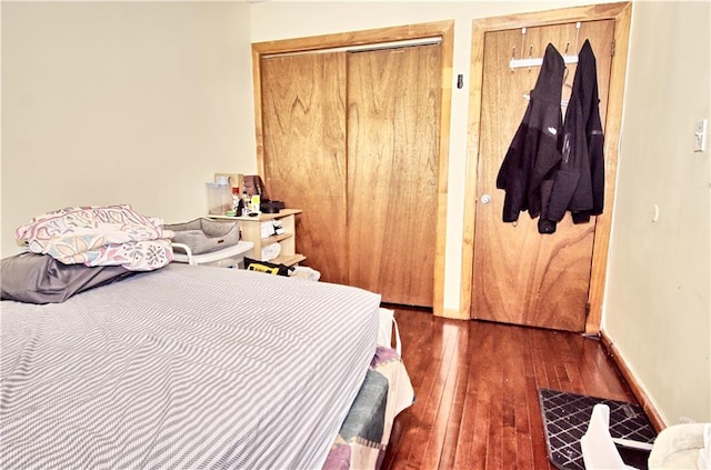 bedroom with hardwood / wood-style floors, a closet, and baseboards
