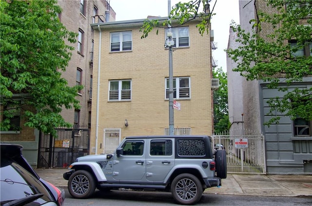 back of property with brick siding and a gate