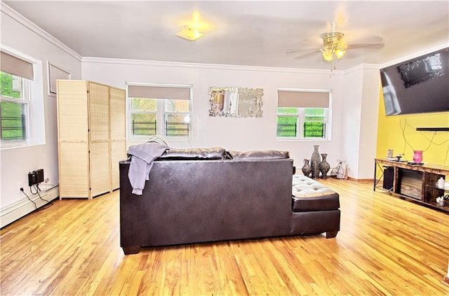 living room with healthy amount of natural light, wood finished floors, a ceiling fan, and crown molding