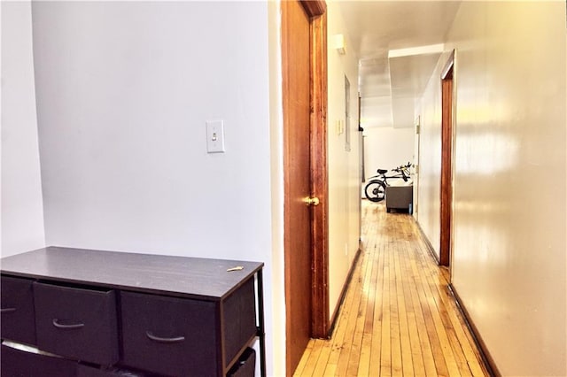 hall with light wood finished floors and baseboards