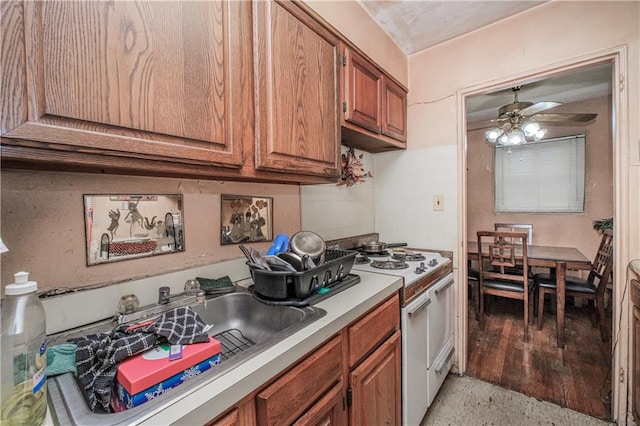 1333 Shore Pkwy Unit A, Brooklyn, NY 11214 - kitchen with white gas range oven, a sink, ceiling fan, brown cabinetry, and light countertops
