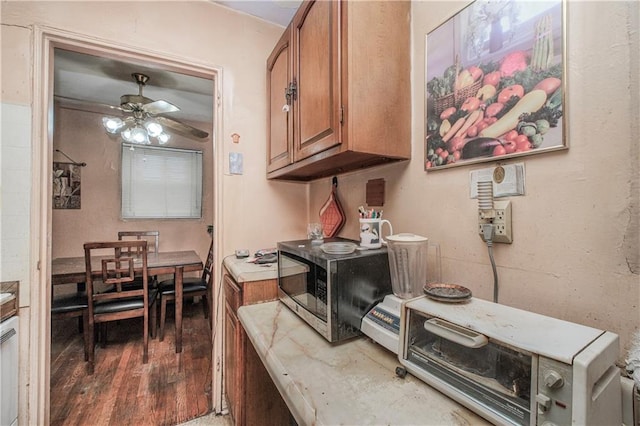 1333 Shore Pkwy Unit A, Brooklyn, NY 11214 - kitchen with stainless steel microwave, brown cabinets, ceiling fan, wood finished floors, and light countertops