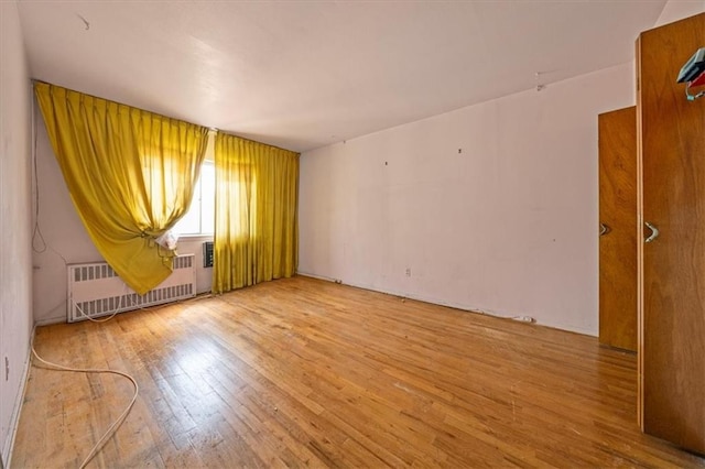 328 Wortman Ave, Brooklyn, NY 11207 - spare room with radiator heating unit and wood finished floors