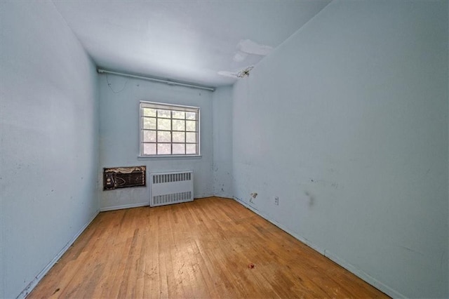 328 Wortman Ave, Brooklyn, NY 11207 - spare room featuring radiator heating unit, wood-type flooring, and baseboards