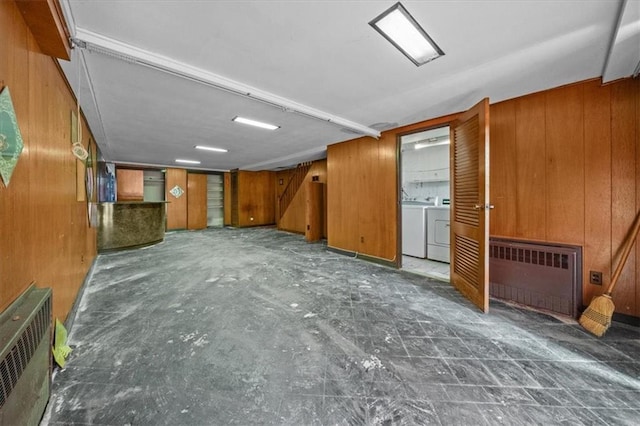 328 Wortman Ave, Brooklyn, NY 11207 - unfurnished living room with separate washer and dryer, wood walls, and radiator