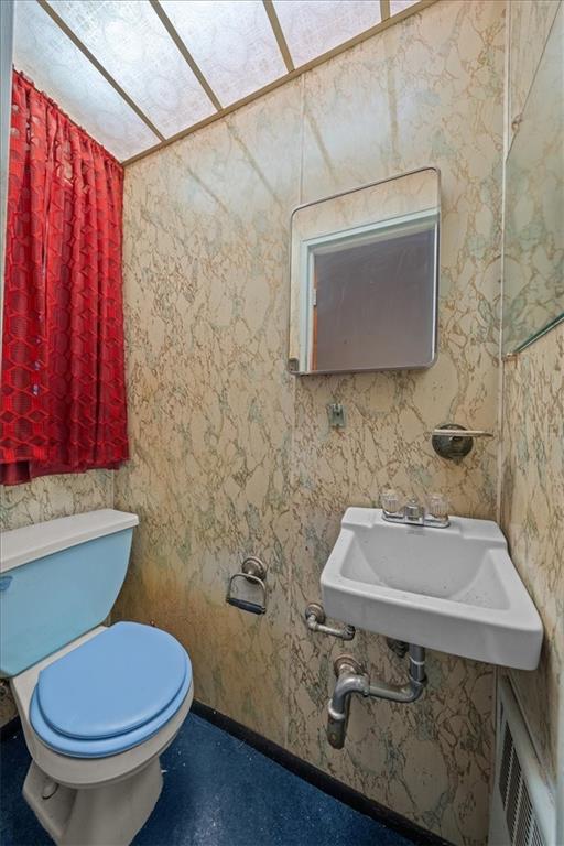 328 Wortman Ave, Brooklyn, NY 11207 - half bathroom featuring toilet, a sink, and baseboards