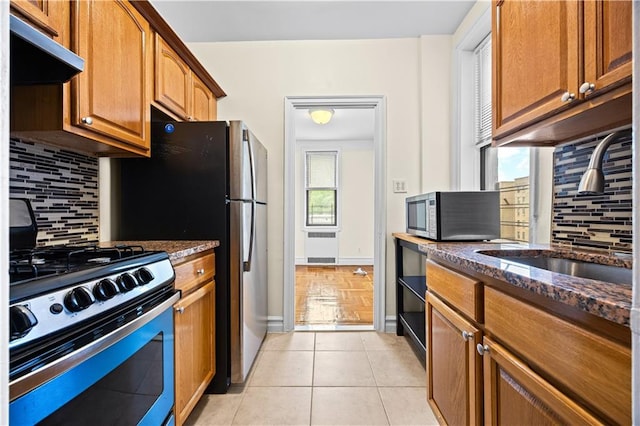 1680 Ocean Ave Unit 4H, Brooklyn, NY 11230 - kitchen featuring appliances with stainless steel finishes, under cabinet range hood, a sink, dark stone countertops, and healthy amount of natural light