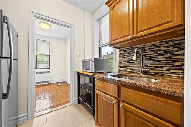 1680 Ocean Ave Unit 4H, Brooklyn, NY 11230 - kitchen with a sink, stainless steel appliances, radiator heating unit, backsplash, and dark stone countertops