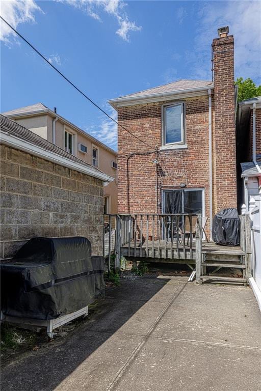 2077 E 22nd St, Brooklyn, NY 11229 - back of property with brick siding, a chimney, and a deck