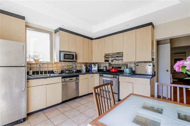 2077 E 22nd St, Brooklyn, NY 11229 - kitchen featuring stainless steel appliances, light brown cabinets, a sink, under cabinet range hood, and backsplash