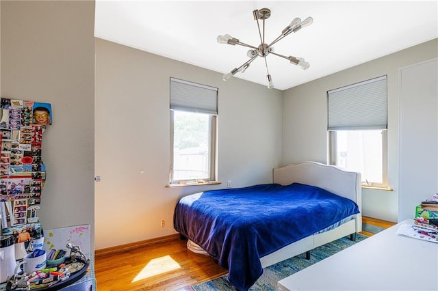 2077 E 22nd St, Brooklyn, NY 11229 - bedroom featuring wood finished floors, a chandelier, and baseboards