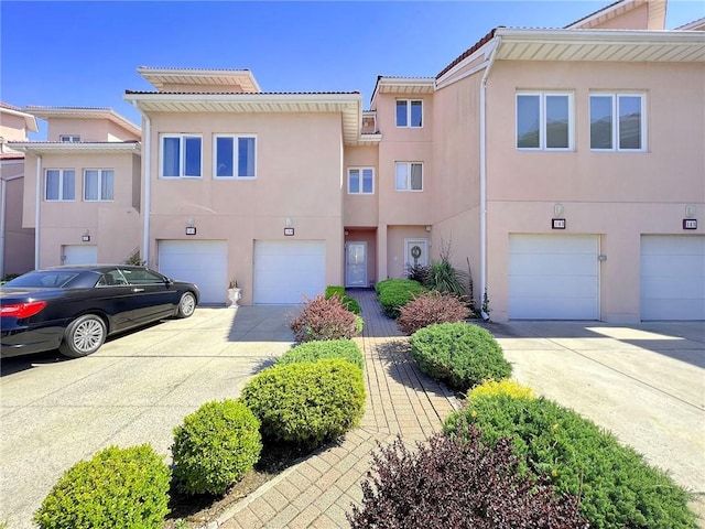 139 Tennyson Dr, Staten Island, NY 10308 - townhome / multi-family property with driveway, an attached garage, stucco siding, and a tile roof