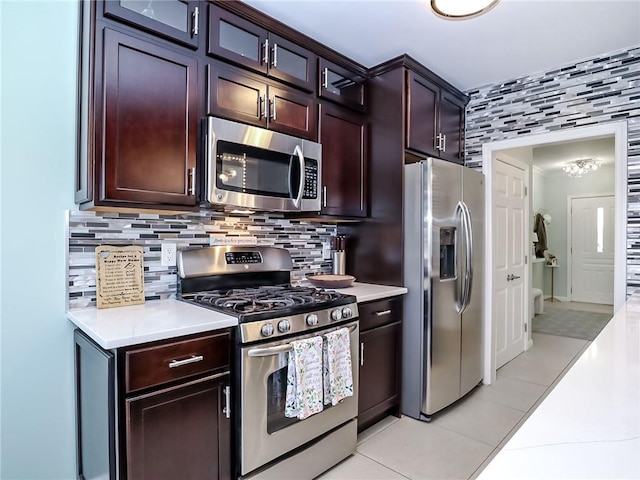 139 Tennyson Dr, Staten Island, NY 10308 - kitchen with appliances with stainless steel finishes, light tile patterned flooring, light countertops, tasteful backsplash, and glass insert cabinets