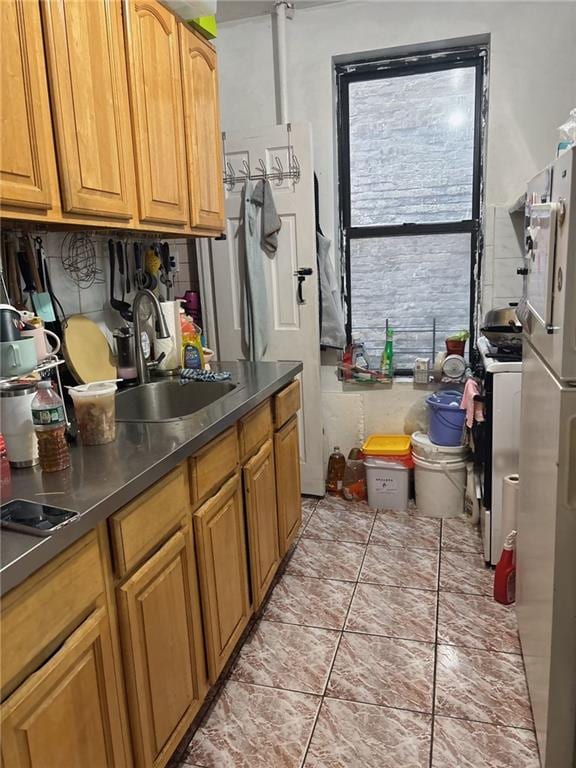 537 56th St, Brooklyn, NY 11220 - kitchen featuring a sink, freestanding refrigerator, tasteful backsplash, range with gas cooktop, and brown cabinets