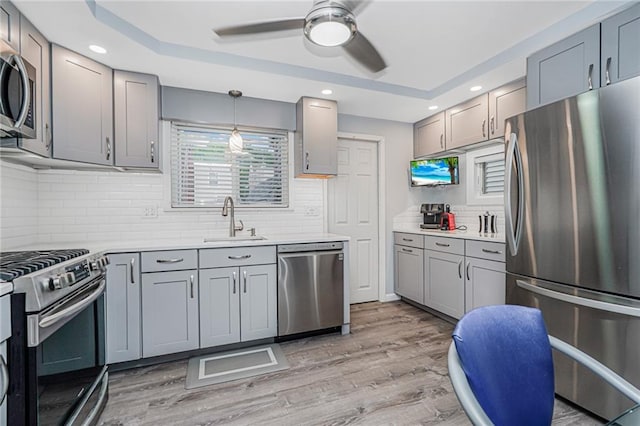 1929 E 36th St, Brooklyn, NY 11234 - kitchen featuring appliances with stainless steel finishes, a sink, ceiling fan, light wood-style floors, and decorative backsplash