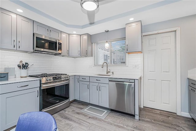 1929 E 36th St, Brooklyn, NY 11234 - kitchen with appliances with stainless steel finishes, gray cabinetry, light wood-type flooring, a sink, and light countertops