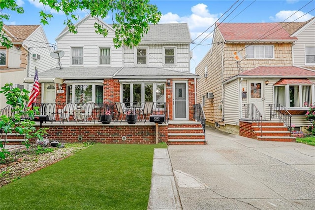 1929 E 36th St, Brooklyn, NY 11234 - view of front of house featuring brick siding, a front lawn, and a porch