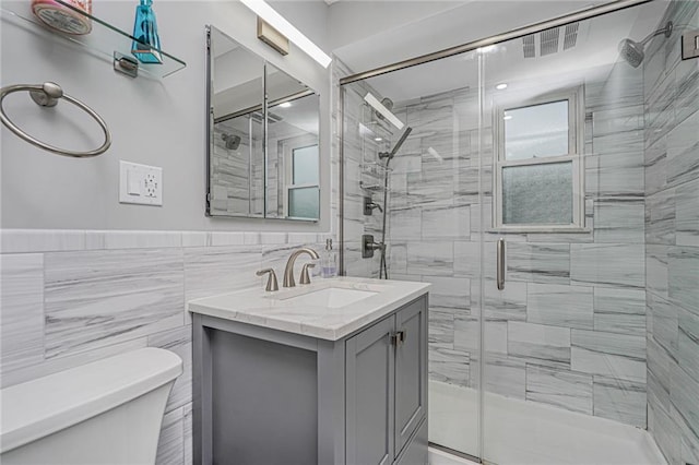 1929 E 36th St, Brooklyn, NY 11234 - bathroom featuring toilet, a shower stall, vanity, tile walls, and wainscoting