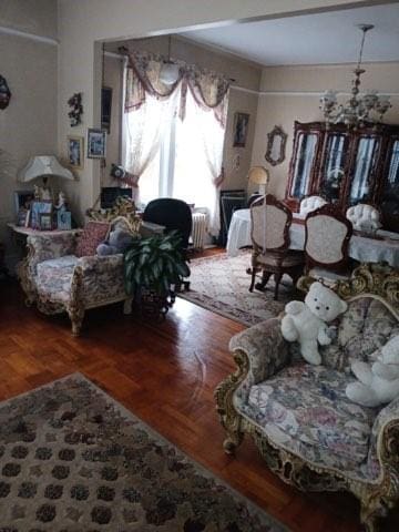 1358 E 35th St, Brooklyn, NY 11210 - living area featuring a chandelier, radiator, and wood finished floors