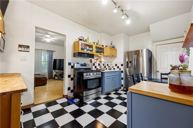 701 127th St, Queens, NY 11356 - kitchen featuring appliances with stainless steel finishes, wooden counters, dark flooring, and extractor fan