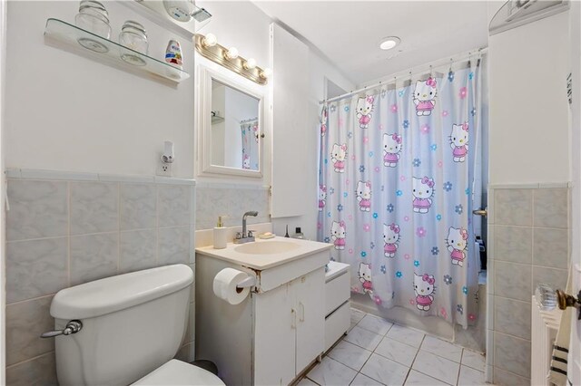 701 127th St, Queens, NY 11356 - bathroom with vanity, toilet, tile walls, shower / bath combo with shower curtain, and wainscoting