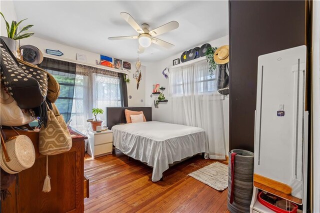 701 127th St, Queens, NY 11356 - bedroom featuring multiple windows, wood-type flooring, and a ceiling fan