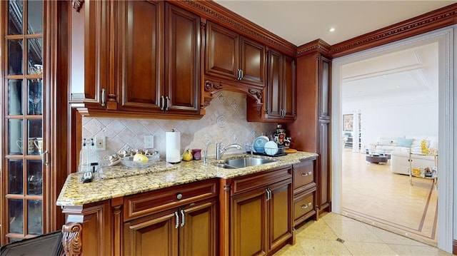 1311 Brightwater Ave Unit 8De, Brooklyn, NY 11235 - kitchen featuring a sink, backsplash, light stone countertops, ornamental molding, and dark brown cabinets