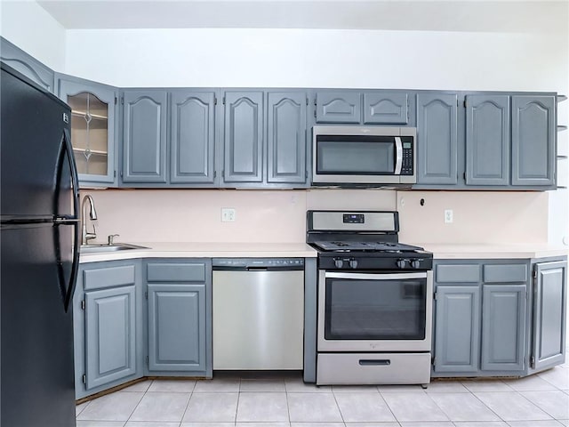 50 Chesebrough St, Staten Island, NY 10312 - kitchen featuring appliances with stainless steel finishes, light countertops, a sink, light tile patterned floors, and glass insert cabinets