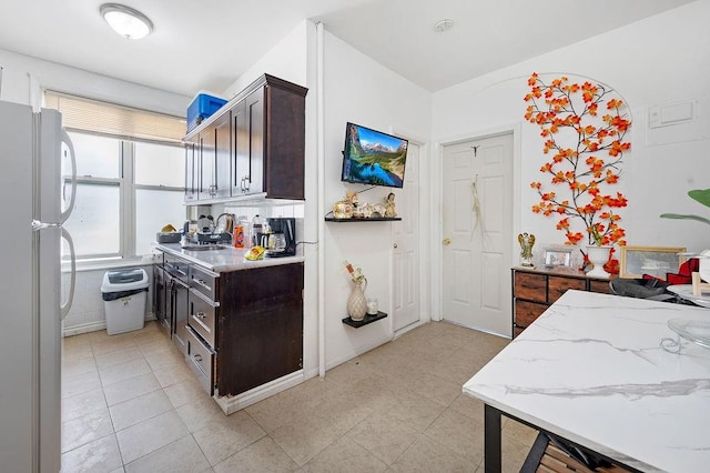 1436 78th St, Brooklyn, NY 11228 - kitchen with freestanding refrigerator, dark brown cabinets, light stone counters, and a sink