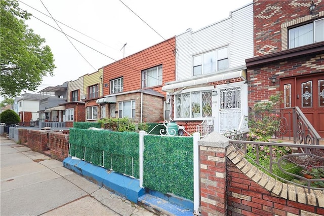 2144 W 6th St, Brooklyn, NY 11223 - view of front of property featuring brick siding, a fenced front yard, and a residential view
