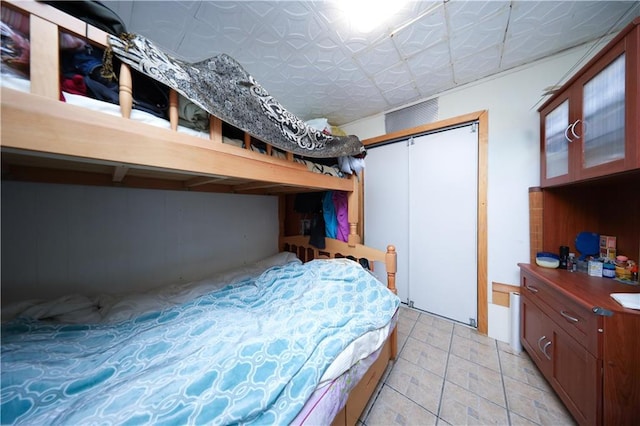 2144 W 6th St, Brooklyn, NY 11223 - bedroom with light tile patterned floors, a closet, and an ornate ceiling