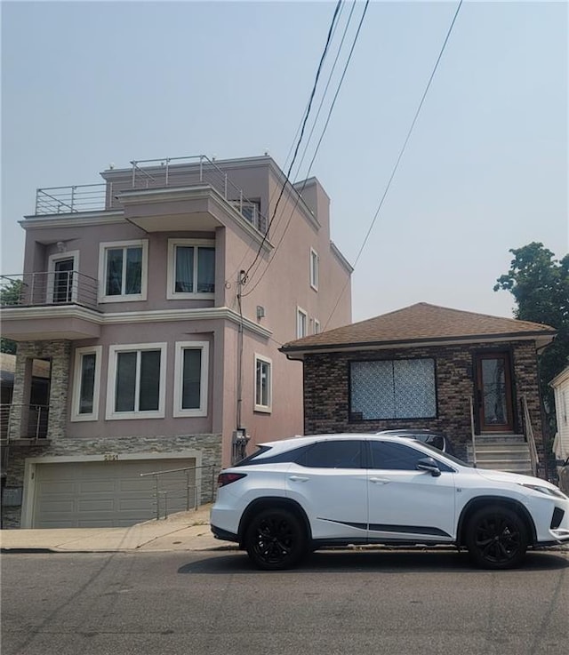 2823 Batchelder St, Brooklyn, NY 11235 - view of front of house featuring stucco siding, a garage, and stone siding