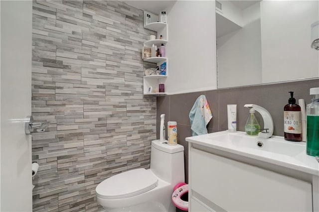 2823 Batchelder St, Brooklyn, NY 11235 - half bathroom featuring tile walls, vanity, toilet, and decorative backsplash