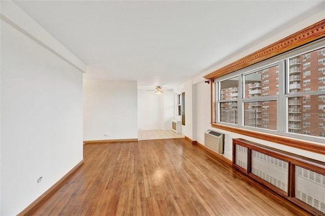 2483 W 16th St Unit 10K, Brooklyn, NY 11214 - spare room with wood finished floors, a wall unit AC, ceiling fan, and plenty of natural light