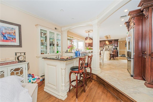 34 Burton Ave, Staten Island, NY 10309 - kitchen with ornate columns, high quality fridge, a breakfast bar, glass insert cabinets, and light wood-style flooring