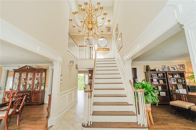 34 Burton Ave, Staten Island, NY 10309 - stairway with a towering ceiling, decorative columns, a chandelier, a wainscoted wall, and a decorative wall