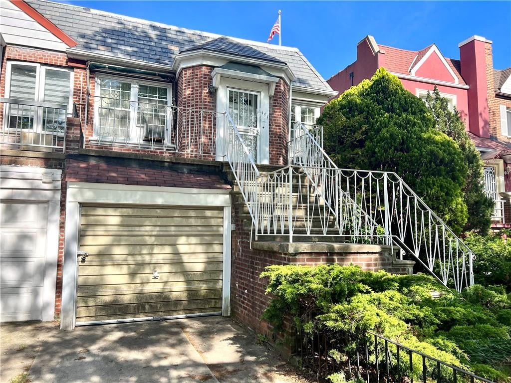 181 Pembroke St, Brooklyn, NY 11235 - view of front of home with a high end roof, brick siding, and stairs