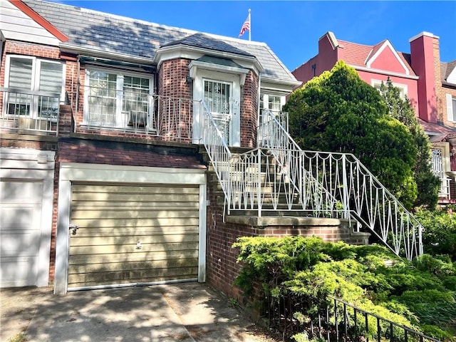 181 Pembroke St, Brooklyn, NY 11235 - view of front of home with a high end roof, brick siding, and stairs