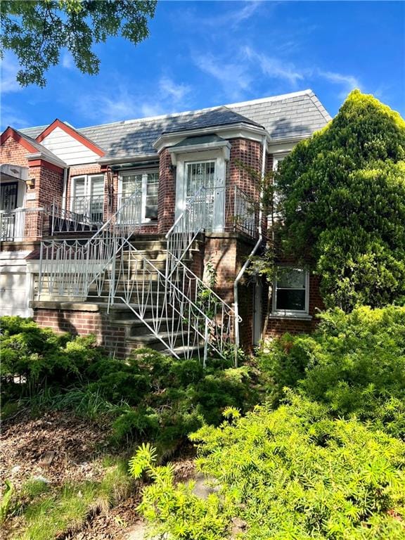 181 Pembroke St, Brooklyn, NY 11235 - view of front of property featuring brick siding, a high end roof, and stairway